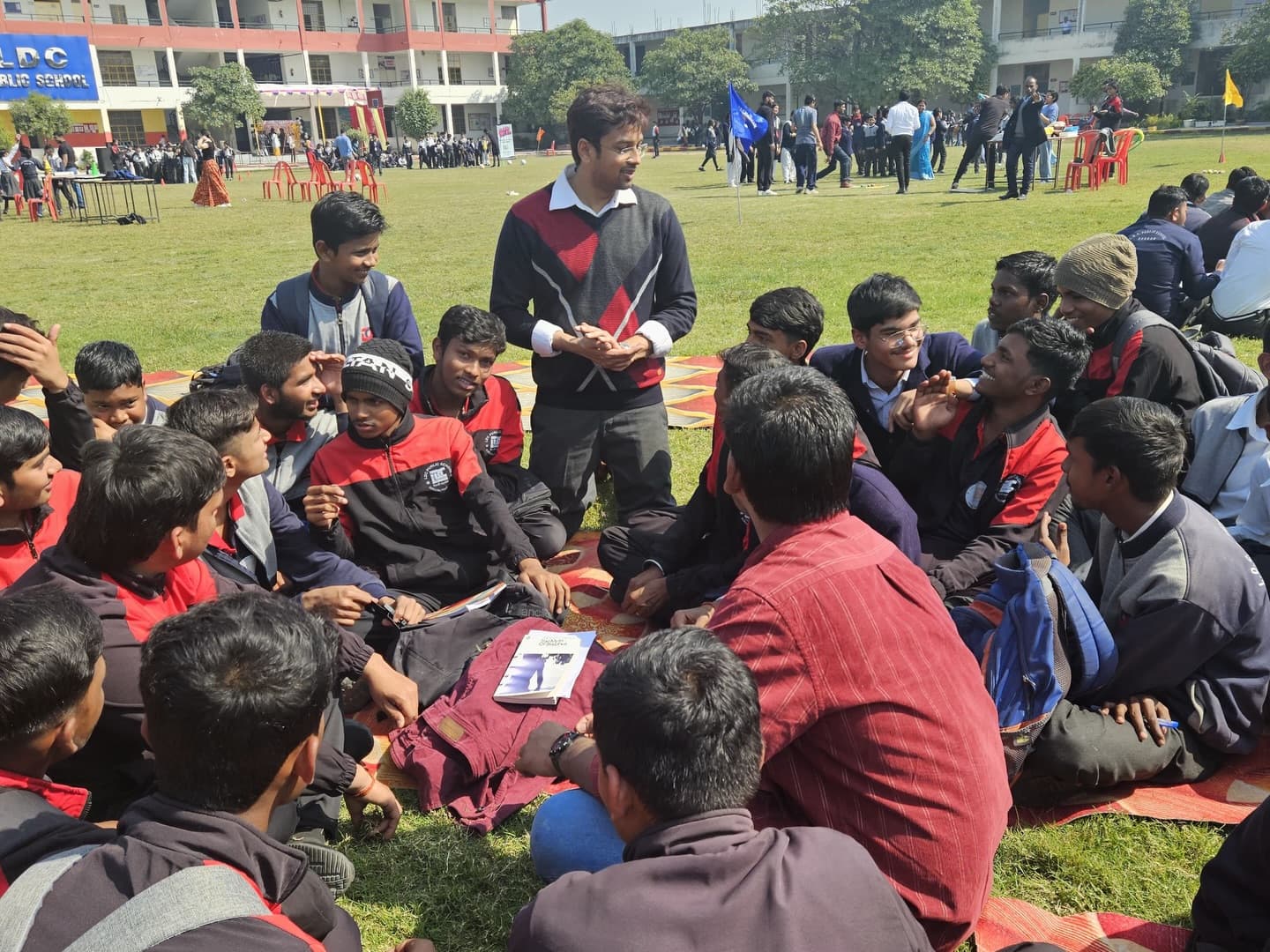 A large group gathered outdoors with a facilitator